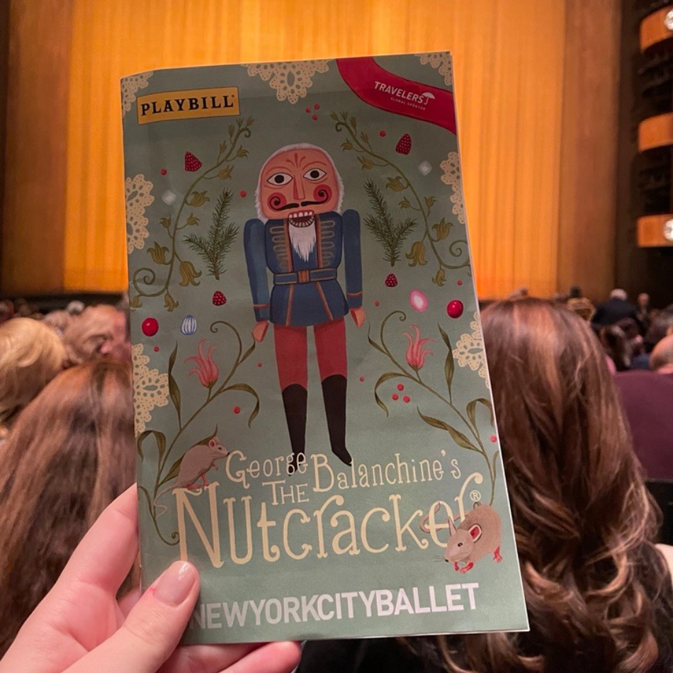 A hand holding up a Playbill of "George Balanchine's The Nutcracker" at New York City Ballet in Lincoln Center. 