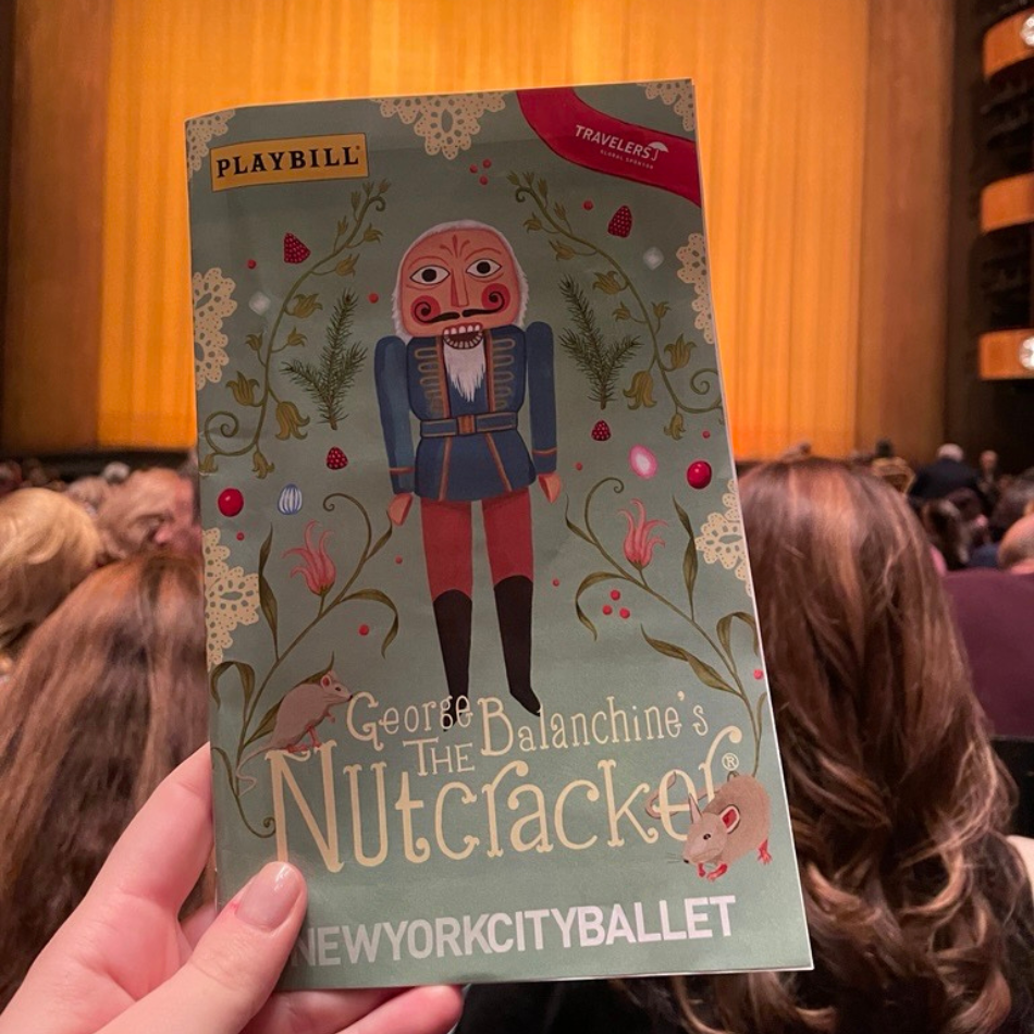 A hand holding up a Playbill of "George Balanchine's The Nutcracker" at New York City Ballet in Lincoln Center.