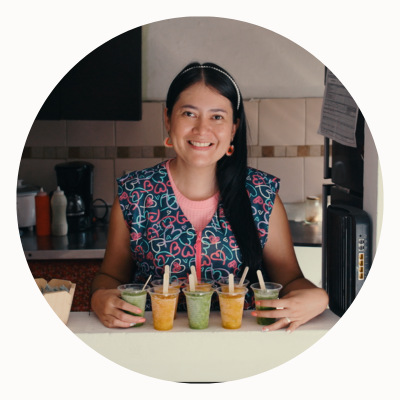 A woman stands in a sales window with fruit drinks.