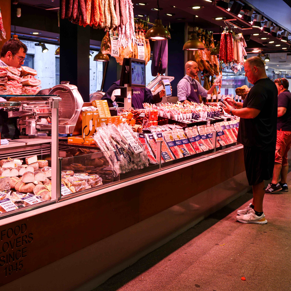 A man orders at the counter of a meat stand at the Boqueria in Barcelona.