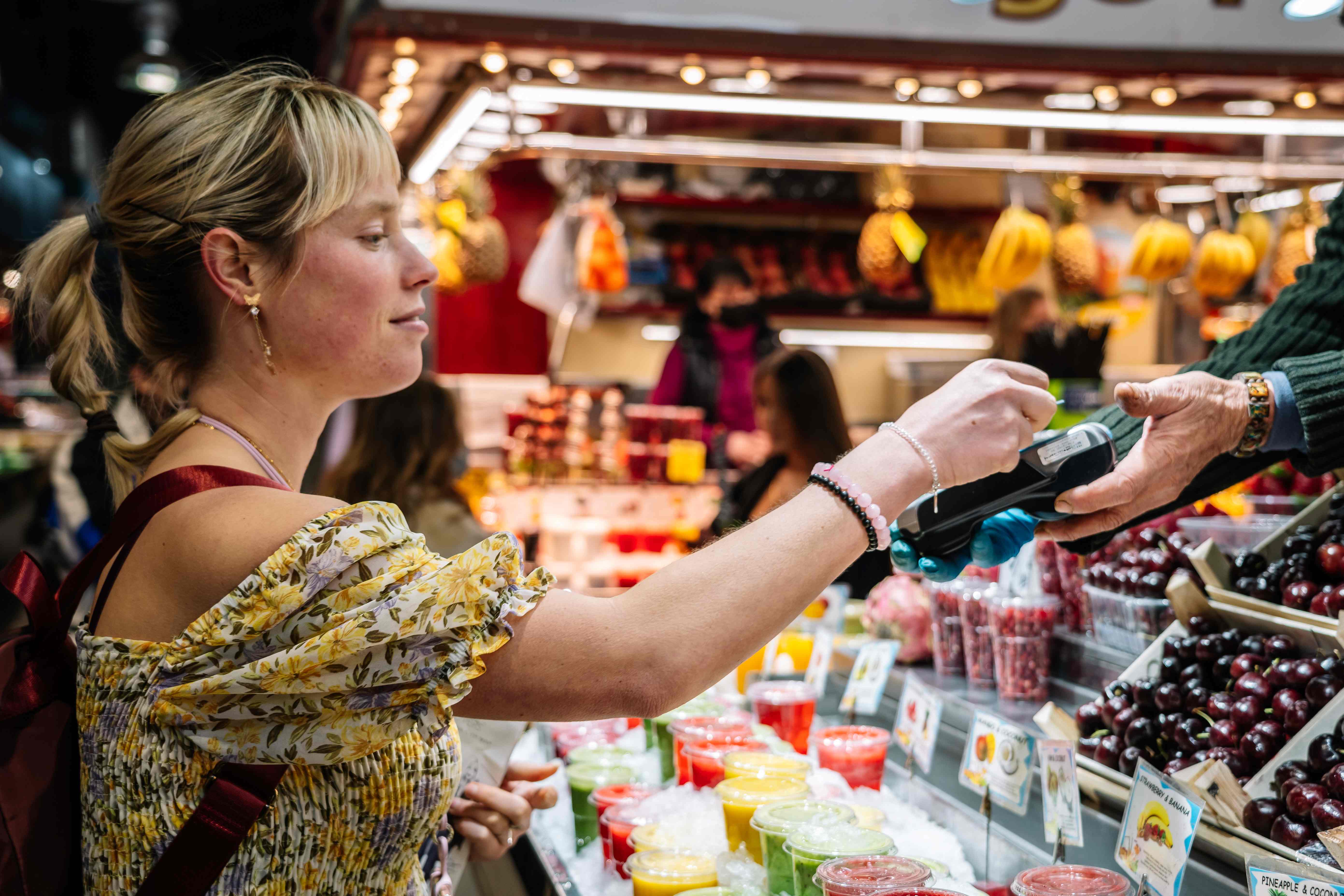 A woman uses a credit card to pay for a purchase at La Boqueria in Barcelona.