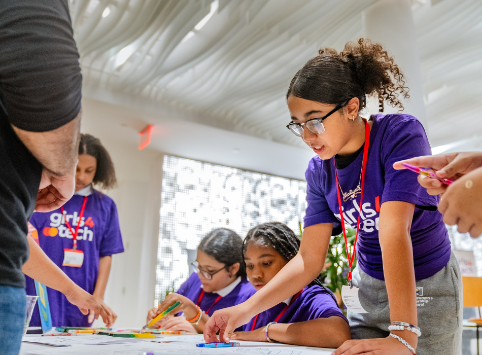 A girl wearing glasses and with her hair in a ponytail works on a cybersecurity problem at a Girls4Tech event.