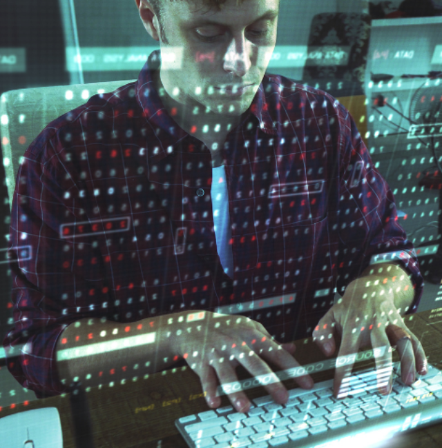 A man types on a keyboard in front of a transparent screen.