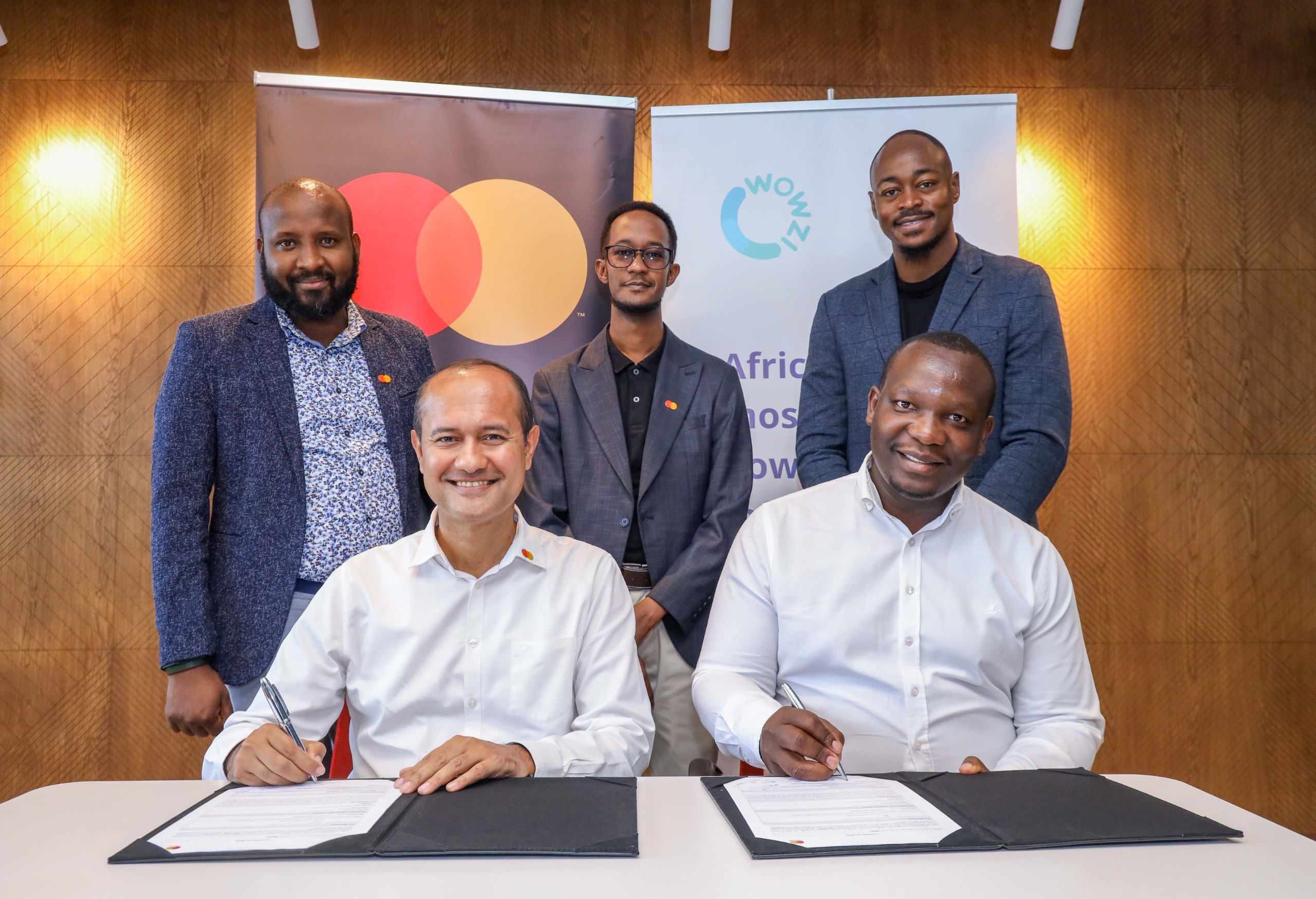 L-R Back): Dickson Chemjor, Digital Lead for East & West Africa, Mastercard; Andrew Letting, Manager, Product Sales, Mastercard; and Brian Mogeni, Co-Founder, Wowzi. (L-R Front): Shehryar Ali, Senior Vice President and Country Manager for East Africa & Indian Ocean Islands, Mastercard; and Mike Otieno, Co-Founder, Wowzi. The executives signed an agreement between Mastercard and Wowzi that will provide content creators with innovative digital card solutions.